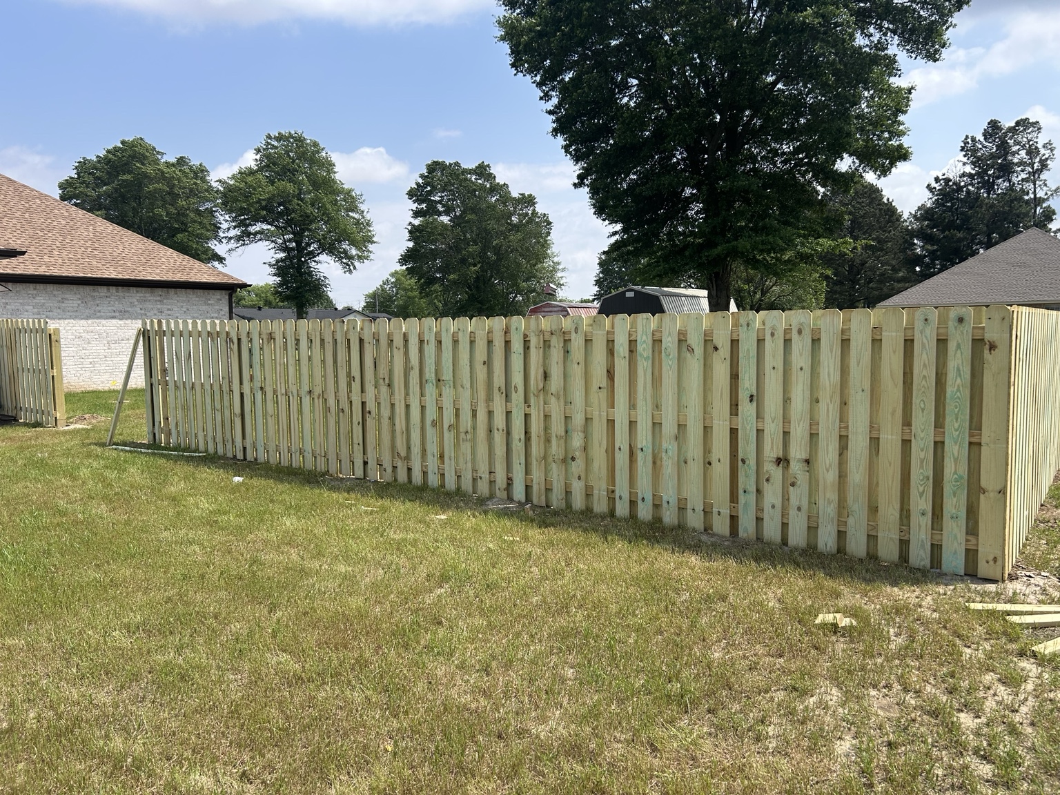 Wood picket fence enclosing a grassy yard